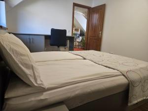 a bed in a room with a desk and a chair at Flower Apartment Cintia in Odorheiu Secuiesc +4 photos