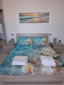 Un dormitorio con una cama con un cuadro en la pared. en Appartamento nuovissimo ad un passo dal mare, en Montesilvano