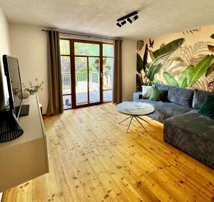a living room with a couch and a table at Garden Eden & Sauna in Neumagen-Dhron