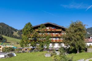 a building on a hill with a tree at Landhaus Perktold in Nesselwängle