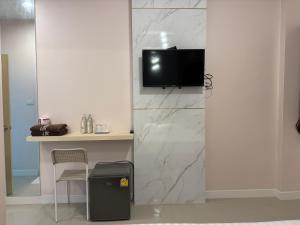a room with a tv on a wall at Pakchong Phubade Hotel in Pak Chong