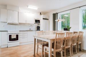 una cocina con armarios blancos y una mesa y sillas de madera. en Ski in/Ski | Sauna | WiFi | Terrace, en Lofsdalen 11 fotos más