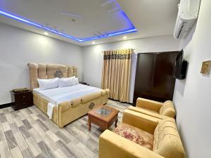 a bedroom with a bed and a couch at Decent Luxury Continental in Islamabad