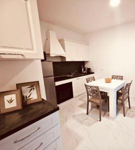 eine Küche mit einem weißen Tisch und Stühlen in einem Zimmer in der Unterkunft Charm Home Alassio in Alassio
