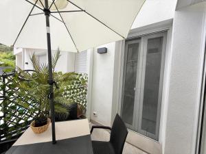 einen Tisch mit einem Sonnenschirm auf einer Terrasse in der Unterkunft Charm Home Alassio in Alassio