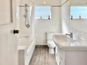 ネルソンにある3-Beds with Sunny Deck & Gardensのトイレと洗面台を備えた白いバスルーム +20枚の写真