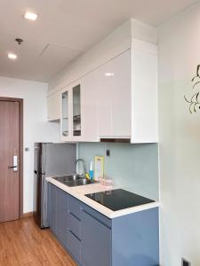 a kitchen with white cabinets and a stainless steel refrigerator at GreenBay- G34030 in Hanoi