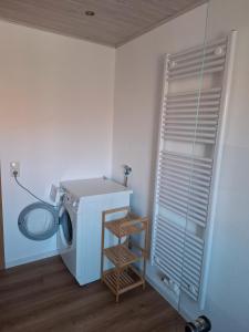 a washing machine in a corner of a room at Ferienwohnung Schönhals in Hochwaldhausen +8 photos