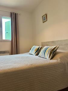 a bedroom with a bed with two pillows on it at appartement au coeur de Saint-Florent à 200m de la plage in Saint-Florent +34 photos