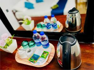 a table with a tea kettle and bottles of water at Hotel EESTEE in Colombo
