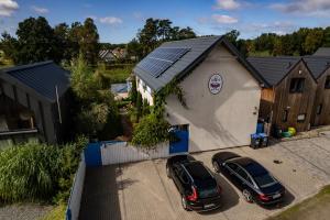 two cars parked in a parking lot next to a building at Domki Kurka Wodna in Dębki