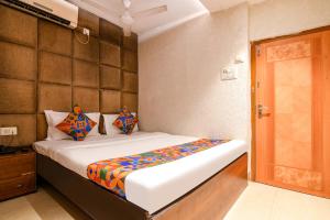 a bedroom with a bed and a wooden door at FabHotel Marina in Tangra +22 photos