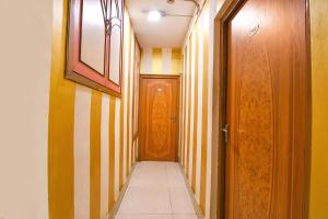 a hallway with yellow and white striped walls and a door at FabHotel Marina in Tangra