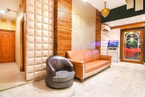 a living room with a couch and a chair at FabHotel Marina in Tangra