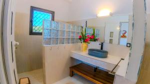 a bathroom with a blue sink and a mirror at belle villa neuve à NOSY BE Ambaro avec 4 chambres in Ambaro +12 photos