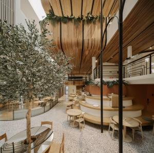 a lobby with tables and chairs and a tree at Double B Hostel in Bangkok +63 photos
