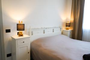- une chambre blanche avec un lit blanc et deux lampes dans l'établissement Netik Apartment - Tuscany, à Cortone