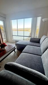 a living room with a couch and a large window at Modern Bayview Apartment by the Water in Emeryville