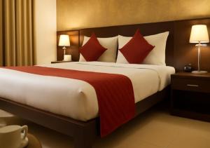 a hotel room with a large bed with red pillows at Atlas Inn Stay Near IGI Airport T3 in New Delhi