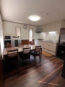 a large kitchen with a table and chairs in it at Hakuba Mountain Chalet in Hakuba