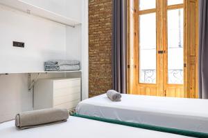 a bedroom with a white bed and a window at NOMADIA en Plaza de la Constitucion 1 in Málaga