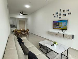 a living room with a couch and a tv at D Aman Infinity Pool Homestay 03 in Alor Setar