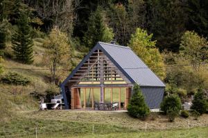 a large glass house with a table in a field at Chalet Aurora in Kanji Dol