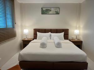 a bedroom with a large bed with towels on it at Coconut Hill Koh Chang in Khlaung Phai Bae
