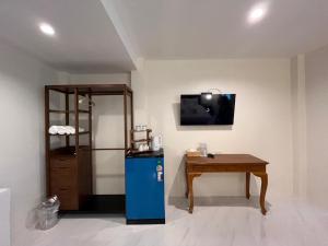 a room with a blue refrigerator and a table at Coconut Hill Koh Chang in Khlaung Phai Bae