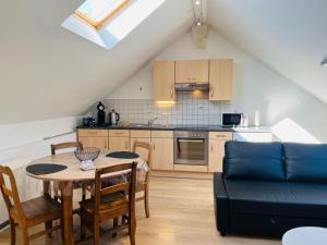 a kitchen and dining room with a table and a couch at Logement cosy à Durbuy in Durbuy
