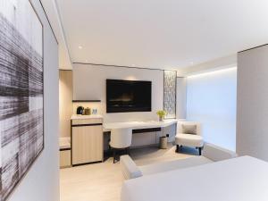a hotel room with a desk and a tv at The Bauhinia Hotel - Central in Hong Kong