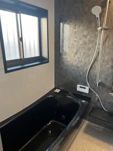 a bathroom with a black tub and a window at BOTH ISUMI - Vacation STAY 06892v in Isumi