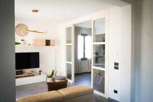 a living room with a couch and a tv at Netik Apartment Cortona - Tuscan Vineyard escape in Cortona +41 photos