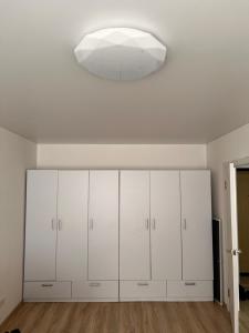 a room with white cabinets and a large light fixture at Полтава Поділ по добова оренда in Poltava