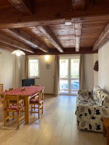 una sala de estar con una mesa y un sofá en La Casa Di Martino, en Cesana Torinese