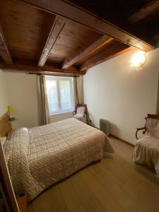 Un dormitorio con una cama grande y una ventana en La Casa Di Martino, en Cesana Torinese