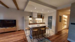 eine Küche mit einer Theke und Hockern in einem Zimmer in der Unterkunft Morriña Atlantica Loft in Pontevedra