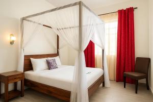 a bedroom with a canopy bed and a chair at Escape Hole in Diani Beach +90 photos