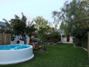 a backyard with a hot tub in the grass at Sandhuis in Riebeek-Kasteel