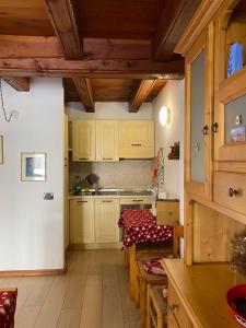 una cocina con armarios amarillos, una mesa y una barra en La Casa Di Martino, en Cesana Torinese