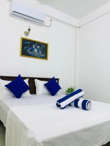 Una cama con almohadas azules y blancas. en ASA VILLA Dickwella, en Dikwella