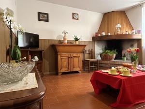a living room with a table with a red table cloth at La locanda del Grottino in Torgiano