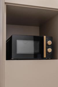 a black microwave sitting on top of a shelf at Dialetti's Nook In Ελλάδα in Thessaloniki