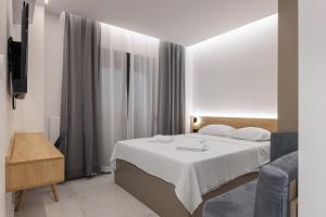 a bedroom with a bed and a tv and a window at Dialetti's Nook In Ελλάδα in Thessaloniki +84 photos