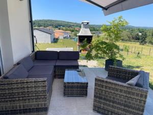 a patio with a couch and chairs and a grill at villa Emilie in Trélissac