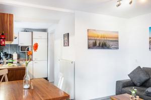 a kitchen and living room with a refrigerator and a table at Nordsee Ferienwohnung Wattwurm in Thunum +17 photos
