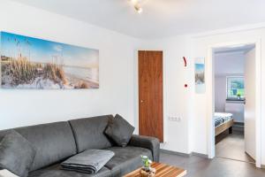 a living room with a couch and a bed at Nordsee Ferienwohnung Wattwurm in Thunum