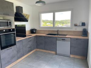 a kitchen with stainless steel appliances and a window at villa Emilie in Trélissac +2 photos