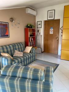a living room with a couch and a book shelf at La mansarda di Orni in Ivrea