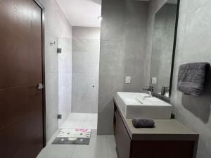 a white bathroom with a sink and a shower at Casa villas del invernadero in Veracruz